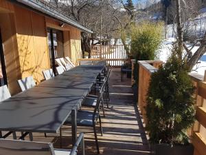 a long table and chairs on a deck at GITE LES TERRASSES 2 in Villard-de-Lans
