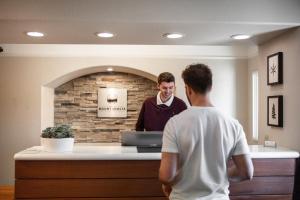 a man standing at a cash register in a store at Inn At Mount Shasta in Mount Shasta