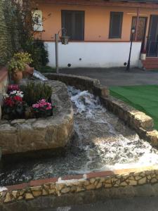 un giardino roccioso con fiori in un cortile di Domus Anna a Torre Annunziata