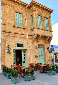 un restaurant avec des tables et des chaises en face d'un bâtiment dans l'établissement Hotel Valide Hanim Konak, à Lefkosa Turk