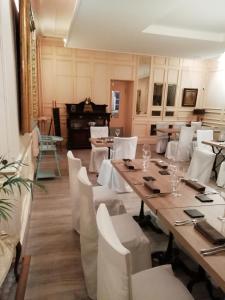 a dining room with a table and white chairs at Le Lion d'Or in Selles-sur-Cher