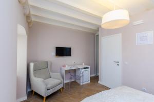 Villa Flores Room في دوبروفنيك: غرفة نوم مع مكتب وكرسي وتلفزيون