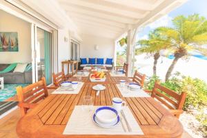 a dining room with a wooden table and chairs at VILLA SAPHIR in Saint Martin