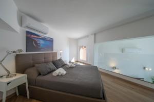 アマルフィにあるAppartamento Dolce Tramontoのベッドルーム1室(ベッド1台、動物2匹の詰め物付)