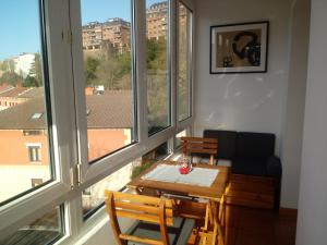 ein Wohnzimmer mit Tisch und Stühlen und Fenstern in der Unterkunft Apartamento Andoaga in San Sebastián