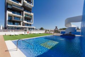 a swimming pool in front of a building at Urbano Blanco Apartments in Calpe