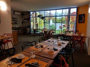 a restaurant with wooden tables and chairs and a large window at Hôtel Raymond 4 Toulouse in Toulouse