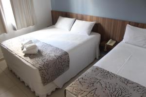 duas camas num quarto de hotel ao lado um do outro em Pousada Caminho Dos Escravos em Diamantina