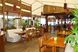 a restaurant with tables and chairs and people in the background at Vida Hermosa in Playa Hermosa
