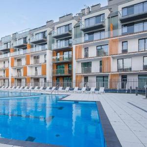 einem Pool vor einem großen Apartmenthaus in der Unterkunft Apartament Limonkowy Kołobrzeg Podczele in Kołobrzeg