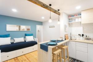 Una sala de estar con un sofá y una cocina. en Lov'Alfama, at home in Lisbon, en Lisboa