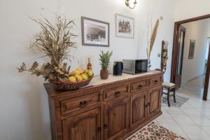 un armario de madera con una cesta de fruta. en Casa Rosario en Riposto