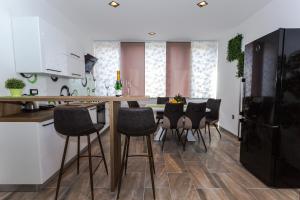 y cocina con mesa, sillas y nevera. en Sensitive relax apartment en Rijeka