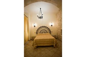 een slaapkamer met een bed en een kroonluchter bij Le Antiche Mura in Lecce