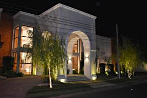 un edificio blanco con entrada arqueada por la noche en Hotel Boutique Las Hortensias, en Pilar