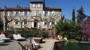 una casa con piscina di fronte a una casa di Bed and Breakfast La Grande Lauzade a Le Luc