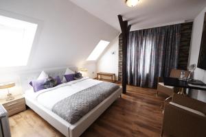 a bedroom with a large white bed with purple pillows at Hotel Wurster Kroog in Bremerhaven