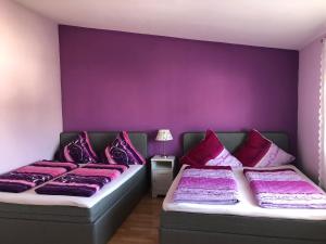 2 camas en una habitación con paredes moradas en Apartment Country Europa-Park Ticket Garantie, en Rust