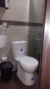 a bathroom with a white toilet and a sink at Hotel Girón Plaza in Girón