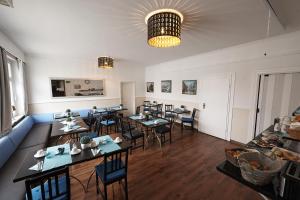 a dining room with tables and chairs in a room at Hotel Wurster Kroog in Bremerhaven