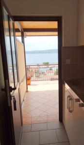 uma porta para uma varanda com vista para o oceano em Apartments Iva em Crikvenica