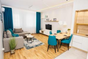 un soggiorno con tavolo e sedie blu di Arena BIG Luxury Apartments a Novi Sad