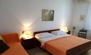 um quarto com uma cama e 2 candeeiros nas mesas em Apartments Iva em Crikvenica