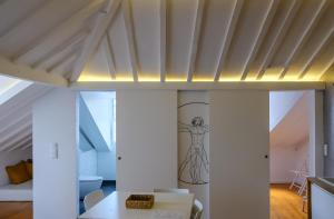 リスボンにあるAlfama Riverview Apartmentsの白い壁と壁に描かれた天井の客室です。