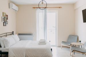 biała sypialnia z łóżkiem, krzesłem i oknem w obiekcie BEST HOUSE, NIRVANA, PATRA w mieście Patras