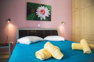 a bedroom with a blue bed with two towels on it at Sophia Central Loft & Apartments in Argostoli
