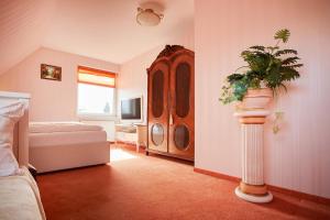 sypialnia z komodą i rośliną w pokoju w obiekcie Ferienhaus De Luxe w mieście Seevetal