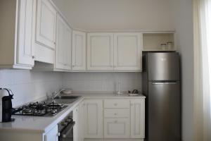 a kitchen with white cabinets and a stainless steel refrigerator at casa Pepi in Olbia +13 photos