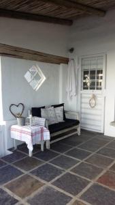 a porch with a bench and a window and a door at Family Tides in Cape Town