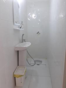 a white bathroom with a sink and a mirror at Thamer apartment in Bursa