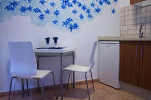 a kitchen with a table and chairs and blue flowers on the wall at Apartamentos Concha in Valle Gran Rey