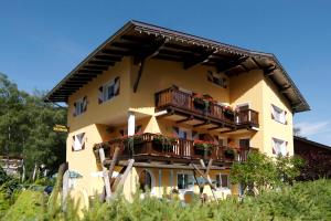 un edificio amarillo con balcones y flores. en Appartements Waldruh en Achenkirch