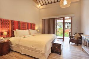 a bedroom with a large bed and a large window at Puri Mas Boutique Resort & Spa in Senggigi