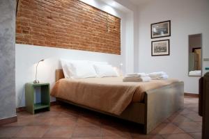 1 dormitorio con 1 cama con pared de ladrillo en La Corte, en Alessandria