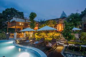 a resort with a swimming pool and a house at Kabeh Jati Garden Villa & Restaurant in Nusa Penida