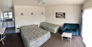 - un salon avec un canapé et une chaise dans l'établissement Blue Seas Motel, à Kaikoura