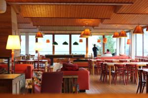 Hôtel Plein Ciel في شامبري: مطعم فيه طاولات وكراسي وناس في الخلف