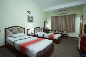 pokój hotelowy z 2 łóżkami i telewizorem w obiekcie Hoang Ha Hotel w Ho Chi Minh