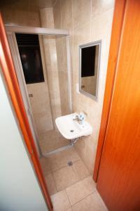 Un baño con lavabo y ducha de cristal. en Hotel Lira - Sólo Adultos, en Ciudad de México