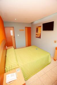 ein Schlafzimmer mit einem grünen Bett und einem Telefon in der Unterkunft Hotel Lira - Sólo Adultos in Mexiko-Stadt