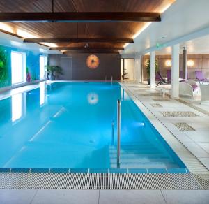 a large swimming pool with blue water at Logis Hotel Restaurant Muller in Niederbronn-les-Bains