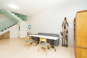 una sala da pranzo con tavolo, sedie e scala di OYO 425 Mojokerto Guesthouse a Mojokerto