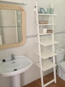 bagno bianco con lavandino e specchio di Apartamentos La Fragata a Es Arenals