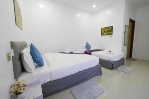 a hotel room with two beds with blue pillows at Mirage Suites de Boracay in Boracay