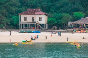 un grupo de personas en una playa con barcos en el agua en catba island hotel en Cat Ba