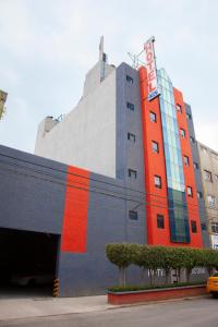 un edificio con una franja naranja y roja. en Hotel Ancona - Sólo Adultos en Ciudad de México